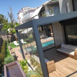Pérgola bioclimática con cerramiento de cortina de cristal