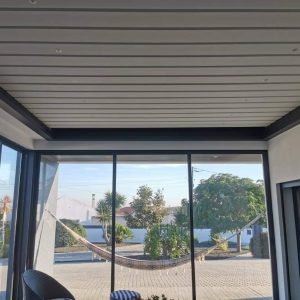 Pérgola bioclimática con cerramiento de cortina de cristal