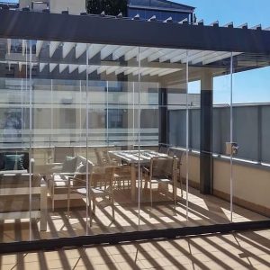 Pérgola bioclimática con cerramiento de cortina de cristal